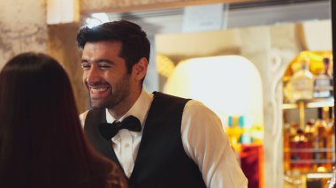 Gülümseyen zeki barmen, gece kulübünde VIP müşterilerle canlı sohbetler yapmak için güzel bir gece partisi atmosferine mükemmel bir servis sunuyor. Vinosity.