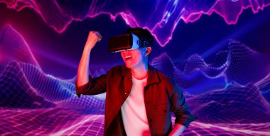 VR kulaklık takan ve soyut arka planda duran sıradan giysili bir adam video oyunu oynuyor. Zeki Asyalı oyuncu oyunu kazanmak için artırılmış gerçeklik teknolojisini kullanıyor. Yaratıcılık.