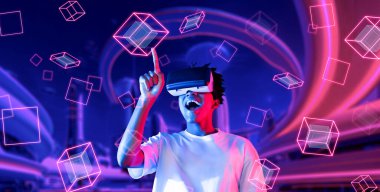 Afrikalı adam metaevrende oyun oynarken heyecanlı ve şekle bakıyor. Gündelik kıyafet öğrenme ve geleceğe dönük şehirde havada süzülen şekle bakma yeteneği olan zeki bir oyuncu. Teknoloji. Yaratıcılık.