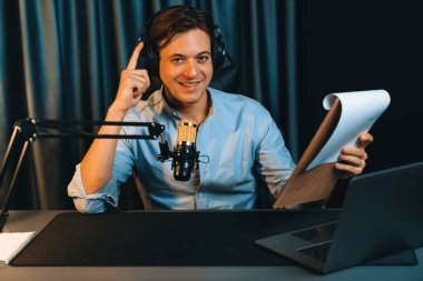 Akıllı yayıncının sunucu kanalı, canlı sosyal medyada canlı yayında konuşma programı ile birlikte modern stüdyoda, kayıt cihazıyla dinleyiciye senaryo okumaktadır. Bireysel.