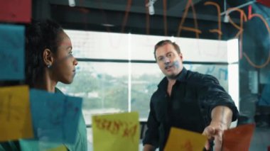 Yetenekli işadamı pazarlama fikrini cam duvardaki proje yöneticisine sundu. Yönetici projeyi yatırımcıya açıklıyor. Zeki iş adamları birlikte çalışıyor, beyin fırtınası yapıyorlar. Yönlendirici.