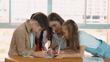 Çizim kitabında işaret kullanarak çeşitli öğrencilerin ve zeki öğretmen çizimlerinin panorama çekimi. Sanat dersinde çizim kitabını kullanarak çok kültürlü bir öğrenci. Rahatlama. Etkinlik.