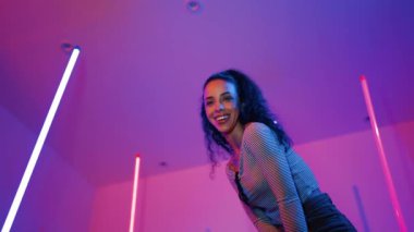 Latin dansçıların kameraya bakıp şehrin pop müziğiyle dans ettiği düşük açılı kamera. Profesyonel çekici hipster, mor veya neon ışıklı hip hop şarkısına geçiyor. Şık bir kumaş. Mutluluk.