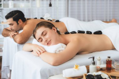 Lüks tatil köyündeki kaplıca salonunda sıcak taş masajı. Gündüz dinginliği ortam, mutlu çift müşterileri bazalt taşı masajının keyfini çıkarıyor. Rahatlatıcı bir sıcaklıkla vücudun üzerinde süzülüyorlar. Sessiz.