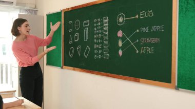 Zeki öğretmen sınıfta fikri açıklarken sevimli öğrenci ödevlerini kontrol ediyor. Not defterine bakıp matematik teorisinden çocuğa bahsederken sınıfta dolaşan çekici bir eğitmen. Pedagoji.