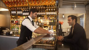 Akıllı barmen, lüks bir tezgahta arkadaşını beklerken limonlu cin kokteyli ikram ediyor. Barmen, canlı gece hayatı parti atmosferinde mükemmel hizmet veriyor. Vinosity.
