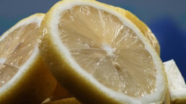 A slice of lemon, bright yellow and vibrantly citric, lies exposed. The yellow flesh, with refreshing juice, reveals its segmented interior. The essence of citrus vibrancy. Slow motion. Comestible. clipart