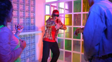 Kafkas dansçısı dans ederken çeşitli arkadaşları gece kulübünde neon ışıkta ayak seslerine bakıyor. Çoklu etnik kökenli hipsterin serbest stil müziğe geçişi ve mutlu bir adamın kameraya bakışıyla. Mutluluk.