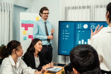 İş adamı, finansal rapor veri analizi veya pazar eğilimi gösterisiyle iş sunumunu şirketin gelecekteki yönetiminde stratejik planlama için büyük bir TV ekranında sundu. Habiliment