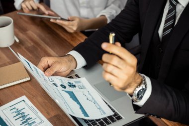 Ofis masasındaki finansal veri raporlarını analiz eden çeşitli bir grup iş analisti. Stratejik pazarlama planlaması için iş zekası analizi çizelgesi ve grafiği.