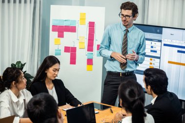 Proje yöneticisi toplantı odasında iş programları, Gantt program programı TV ekranında. Çoklu etnik çeşitlilik iş adamları ve modern iş projesi yönetimi. Çok titiz.