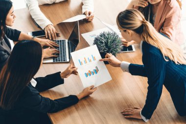 Modern işyeri ofisindeki diğer iş kadınlarıyla grup toplantısındaki iş kadını masada dizüstü bilgisayar ve belgelerle konuşuyor. Kurumsal iş dünyası konsepti. uds