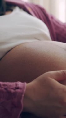 Hamile bir kadın çocuğuna bakarken kendini mutlu hissediyor. Hamile karnında bebek taşıyan hamile bir anne. Doğum öncesi bakım ve kadın hamileliği konsepti.