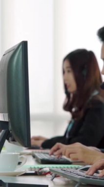 Ofiste çalışan kulaklık takan işadamları uzak müşteri ya da meslektaşlarını desteklemek için çalışıyorlar. Arama merkezi, tele pazarlama, müşteri destek acentesi telefon görüşmesinde hizmet sunar.