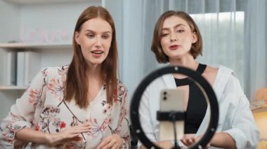 Etkilenen iki ortak canlı yayında video görüntülerini çekiyor makyaj malzemesi prim sosyal medya veya blog. Kozmetik stüdyosu ışıklandırmalı mutlu genç kız çevrimiçi pazarlama oturumu yayını için..