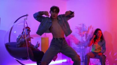 Çok kültürlü bir arkadaş kürsüde otururken Asyalı yetenekli bir dansçı modern müziğe geçiyor. Profesyonel dansçı, hipster takımı tezahürat yaparken ve desteklerken enerjik adımlar atıyor. Mutluluk.