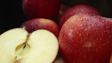 Makrografi, taze elma dilimleri çarpıcı bir siyah arka plana karşı bir kesme tahtasına yerleştirilmiştir. Her yakın çekim elmaların canlı dokusunu ve canlı renklerini yakalar. Geliştirilebilir.