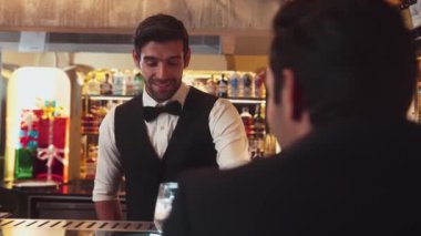 Akıllı barmen, lüks bir tezgahta arkadaşını beklerken limonlu cin kokteyli ikram ediyor. Barmen, canlı gece hayatı parti atmosferinde mükemmel hizmet veriyor. Vinosity.