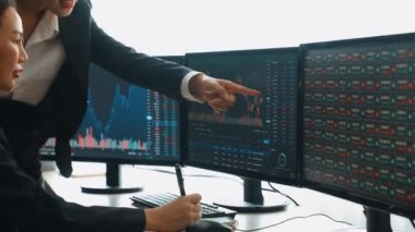 Menkul kıymetler borsası pazarlamasını inceleyen borsa yatırımcıları, zarar ve kazanç için mum bar fiyatlarını analiz eden monitörlere bakıyor. Filizlenen