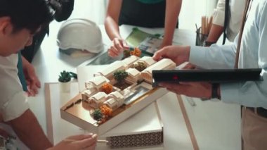 Profesyonel mimar mühendis oturmuş müdüre ev planını açıklarken. Toplantı odasında inşaat hakkında konuşurken akıllı tasarımcının planının havadan görünüşü. Hizalama.