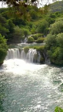 Hırvatistan 'ın Krka ulusal parkındaki Krka nehrindeki şelalelerin panoramik manzarası. Krka Ulusal Parkı, Sibenik kentinin sadece birkaç kilometre kuzeydoğusundaki Hırvatistan ulusal parklarından biri..