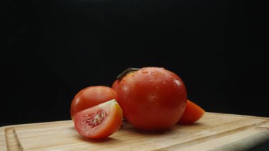 Macrography, slices of tomato rest elegantly on a rustic cutting board against a dramatic black background. Each close-up shot captures the juicy texture and rich colors of the tomatoes. Comestible. clipart