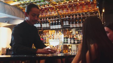 Barmen limonata ile süslenmiş votka kokteyli hazırlıyor. Lüks gece kulübü özel ekşi içeceğinde güzel müşterilere servis ediliyor. Şık gece hayatı miksoloji partisi. Vinosity.