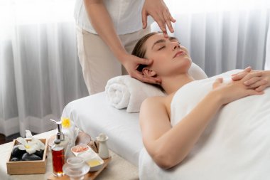 Kafkasyalı kadın stres önleyici kafa masajından ve lüks tatil beldesi ya da otel spa salonundaki modern ışık ortamında yüz güzelliği eğlencelerini şımartmaktan hoşlanıyor. Sessiz.