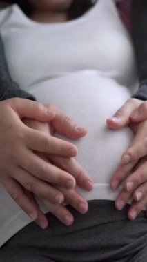 Hamile çift, evde sevgi hisseder ve rahatlar. Hamile bir kadın hamile karnında bebek taşıyor. Baba, hamile anneye göz kulak ol. Annelik ve hamilelik bakımı kavramı.