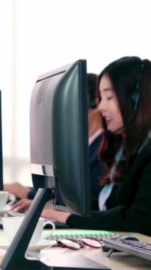 Ofiste çalışan kulaklık takan işadamları uzak müşteri ya da meslektaşlarını desteklemek için çalışıyorlar. Arama merkezi, tele pazarlama, müşteri destek acentesi telefon görüşmesinde hizmet sunar.