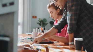 Akıllı proje yöneticisi logo tasarımını seçen iş adamıyla birlikte çalışıyor. Profesyonel iş adamları renk paletlerine bakarken pazarlama stratejisini tartışıyor ve planlıyorlar. Sempozyum.