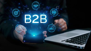 İş adamı B2B peyzajında geziniyor, iş-iş bağlantılarını geliştirmek için kullanım teknolojisi kullanıyor. B2B etkileşimini yeniden şekillendiren keşifler, iş-iş stratejilerinde yenilikleri yönlendiren araçlar. Kullanıcı Kimliği