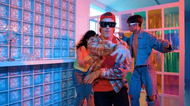 Değişik takımlarla dans ederken süslü gözlük takan yakışıklı hippi serbest stil müzikle mutlulukla dans ediyor. Beyaz hipster kulüpte parlak neon ışıkta sokak dansı yapıyor. Mutluluk.