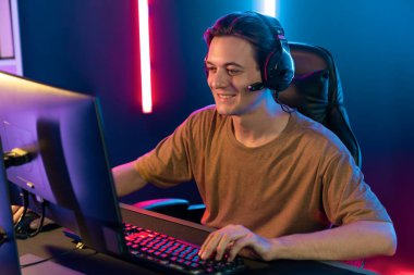 Kazanmak için çevrimiçi oyun oynayan akıllı flama makinesinin sunucu kanalı, neon ışıklı odada seçilen takım yarışması için izleyicilerle birlikte canlı yayında canlı yayında kulaklık takıyor. Bireysel.