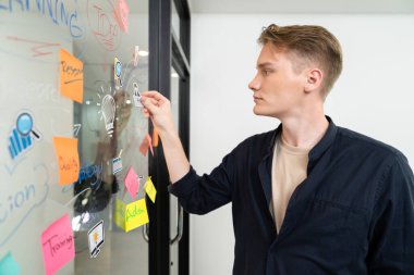 Kafkasyalı profesyonel iş adamının zihin haritası ve renkli yapışkan notlar kullanarak iş pazarlama fikrini kendine güvenle sunuşunun yakın görüntüsü. Proje konseptini başlat. Portre. Tertemiz..