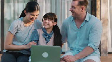 Father, mother and daughter focus laptop at terrace with garden view outside house. Parent use outdoor activity to communicate young generation about environment care cross generation gap. Divergence. clipart