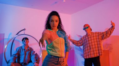 Çekici mutlu dansçı kameraya bakarken zeki kadın neon ışıkla kafiyeli hareket ediyor. Profesyonel İspanyol şarkıcı çeşitli arkadaşlarıyla renkli kıyafetler giyerken break dans yapıyor. Mutluluk.