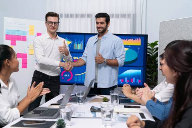 Analist ekip lideri, iş zekası ya da BI gösterge paneli ile FIntech yazılım gücünü kullanarak başarılı veri analizi toplantısından sonra iş arkadaşıyla tokalaştı. Tedbirli