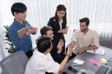 Çeşitli ofis çalışanları stratejik iş pazarlama toplantısı üzerine anlaşma yaptıktan sonra el sıkışıyor. Takım çalışması ve olumlu tutum verimli ve destekleyici bir iş yeri yaratır. Tedbirli