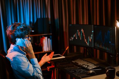 Genç tüccardan komisyoncuya, küresel piyasadaki kar döviz kuru yatırımına danışmanlık yaparak bilgisayar ekranında gerçek zamanlı olarak Neon Light Modern Office 'de. Borsa kavramı. Toplayıcı.