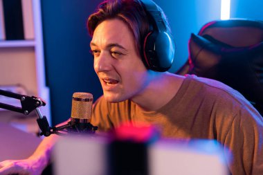 Oyun kanalı, online oyun oynayan akıllı flamalı oyun sunucusu, kulaklık takan, neon ışıklandırma odasındaki takım oyuncusuyla akıllı telefondan canlı yayında konuşan izleyiciler. Bireysel.