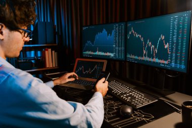 Akıllı telefonlara odaklanan genç tüccar ile piyasa stoku grafiğindeki dizüstü bilgisayarla Neon Light Modern Ofis 'teki gerçek zamanlı ekranları karşılaştırıyor. Dinamik döviz kurunu analiz etme kavramı. Toplayıcı.