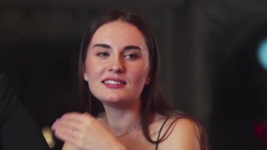 Lüks bir kokteyl barında grup arkadaşıyla konuşan güzel bir kadının portresi. Gece kulübünde sosyetik etkileşim için doğal yüz güzelliğini kostüm içinde yakalamak. Vinosity.