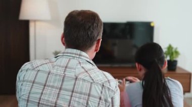 Büyükbaba ve torun birlikte konsol oyunu, eğlence medyası oynuyorlar. Eski kullanım teknolojisi yeni nesil ile iletişim kurar. Nesiller arası uçurum aile bağını güçlendirir. Uyumsuzluk.