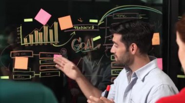 Akıllı yatırımcılara pazarlama fikri ya da finansal planı sunan profesyonel iş adamı. Yönetici yönetici paylaşıyor, konuşuyor, kooperatif iş arkadaşlarıyla birlikte çalışıyor. İş konsepti. İzleme