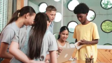 Akıllı robotlar sınıfta dizüstü bilgisayar ekranını işaret ederken, beyaz bir öğretmen yorum yapıyor ya da öğrencilere tavsiye veriyor. Öğretmen bilgisayar kullanırken çeşitli öğrencilerin ders verirken not alması. Öğretim