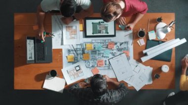 Akıllı mimar yazma fikrinin yukarıdan aşağı görüntüsü toplantı masasında şablon ve tablet bina inşaatı ile yapışkan notta. Yöneticinin not alıp paylaşma planını havadan izlemesi. Sempozyum.