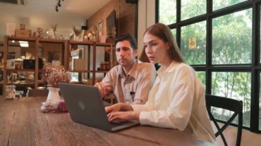 Baharda Cafe Garden 'da dizüstü bilgisayarda çalışan genç bir çift kahve dükkanındaki dinginlik ortamının tadını çıkarıyor. Uzaktan çalışan ya da blog yazan dijital göçebe ya da üniversite öğrencisi. Yararlı