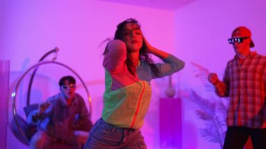 İspanyol hipster renkli kıyafetler giyer ve serbest stil müziğe el sallar. Profesyonel break dansçı neon ışıklarıyla ve modern stüdyo arkadaşlarıyla coşkuyla dans ediyor. Mutluluk.