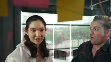 Genç kendine güvenen iş kadını projeyi uzman yatırımcıya sundu. Profesyonel proje yöneticisi başlangıç projesini açıklamak için yapışkan notlar kullanır, beyin fırtınası fikirlerini yatırımcıya paylaşır. Yönlendirici.